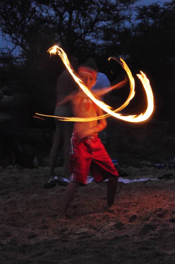 Criança faz malabarismo com fogo durante festa na praia de Little Beach, ao sul de Kihei, em Maui, no Havaí